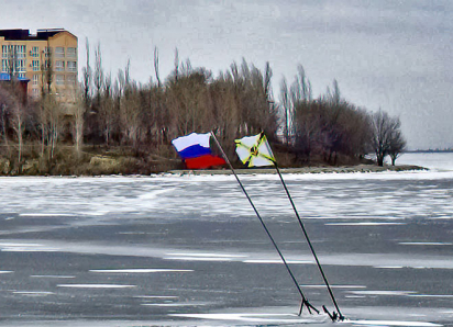 Символические флаги на льду реки у Бородинского моста в Камышине наклонились от ветра, но их снова укрепили  металлическими конструкциями