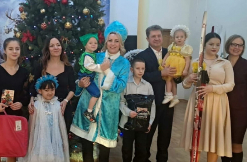 Глава Камышина Станислав Зинченко взял на руки девочку для новогоднего фото под елкой