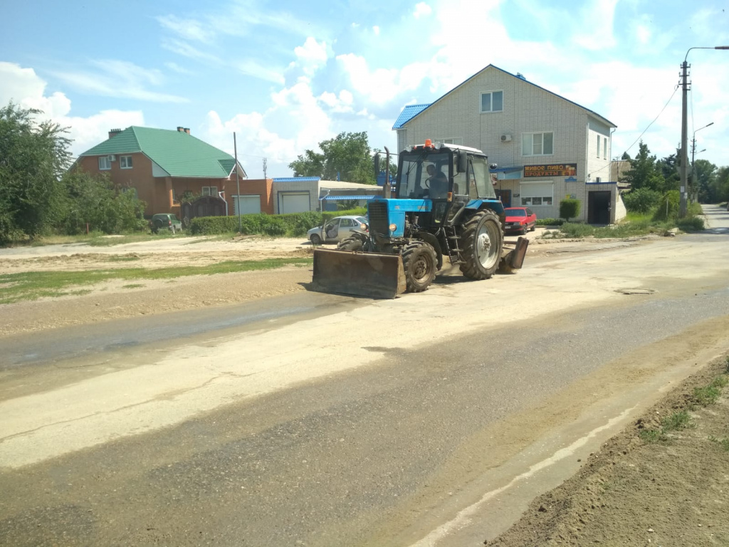 Тракторы зачищают проезжую часть у пустой площадки на улице Набережной, где  когда-то находился Дом офицеров в Камышине